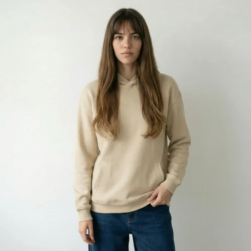 Woman wearing a beige hooded jacket and jeans.