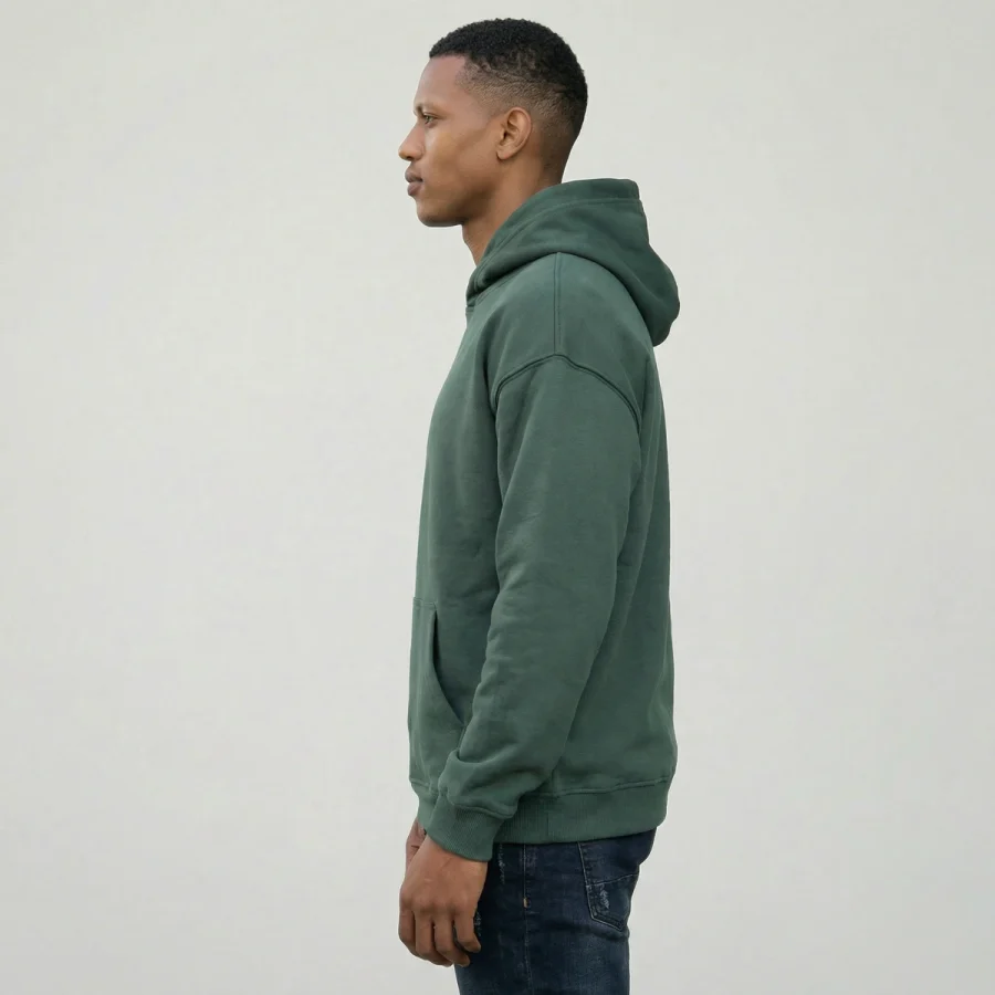 Homem com hoodie verde e jeans, de costas e de lado.