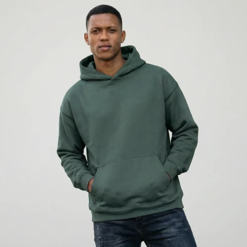 Man wearing a green hooded sweatshirt and jeans, Oversize Hoodie.