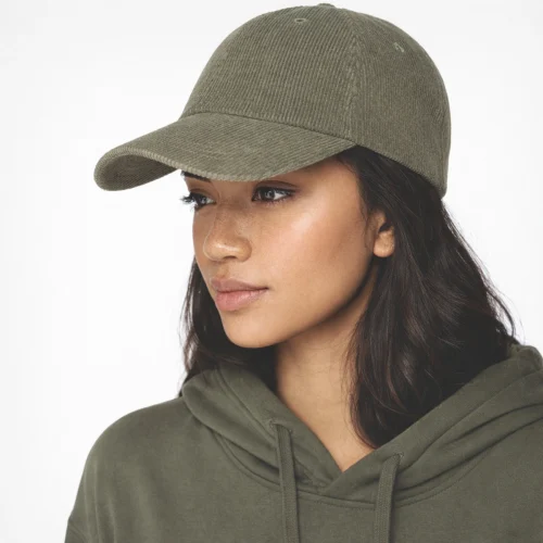 Woman wearing a hat and olive green hoodie.