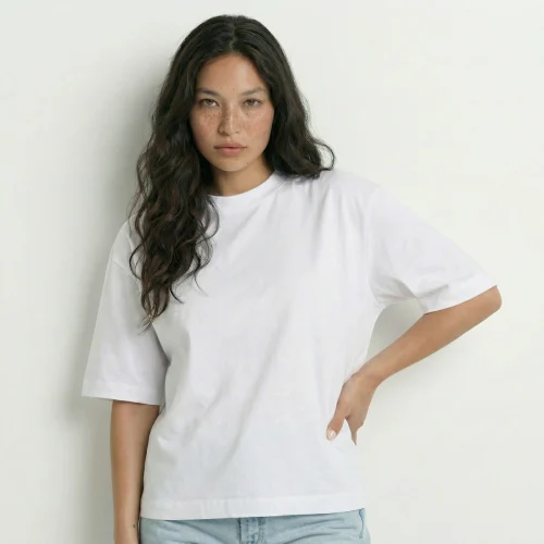 Woman with brown hair wearing a white Over Boxy t-shirt.