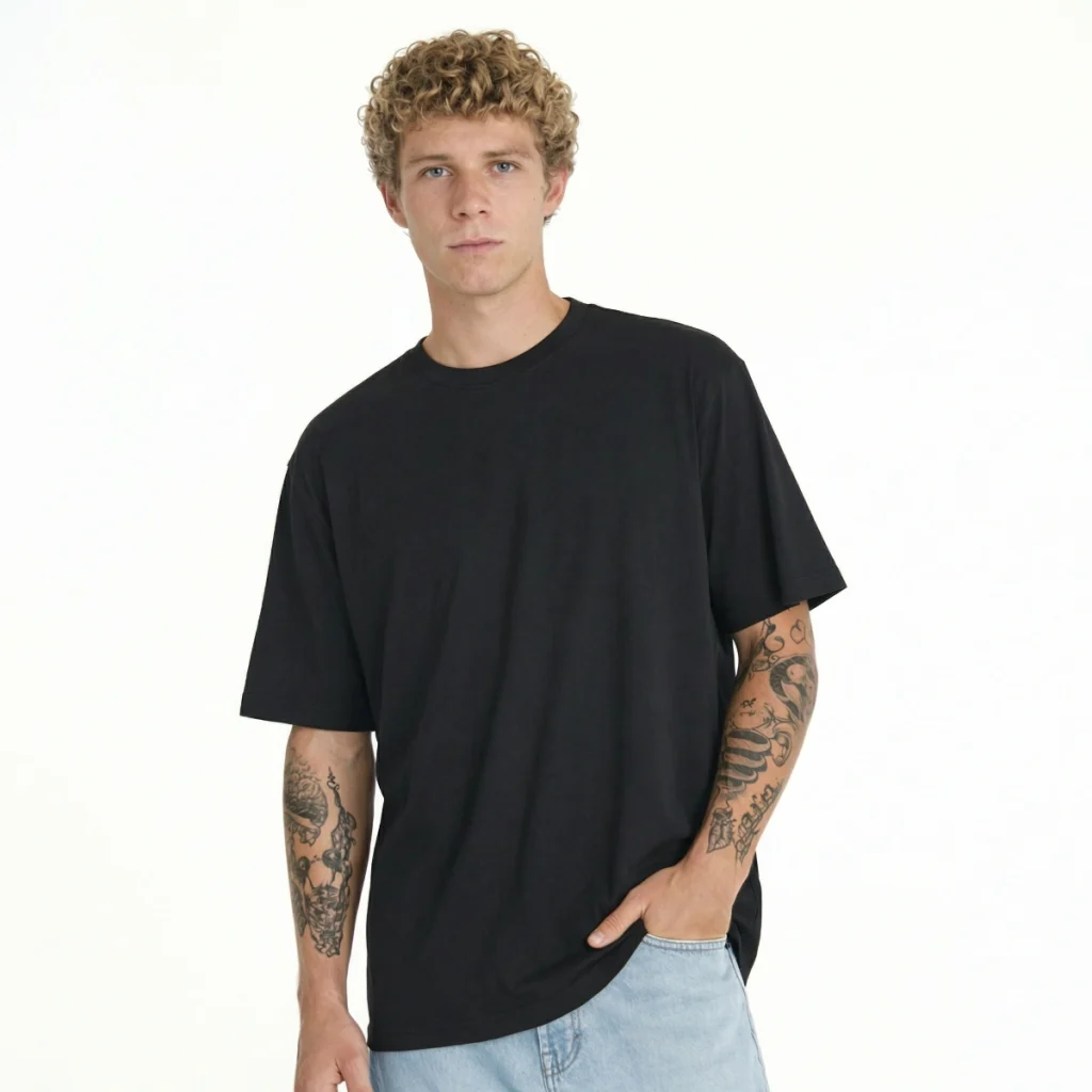 Homem com T-Shirt Urban Oversize preto e tatuagens nos braços.