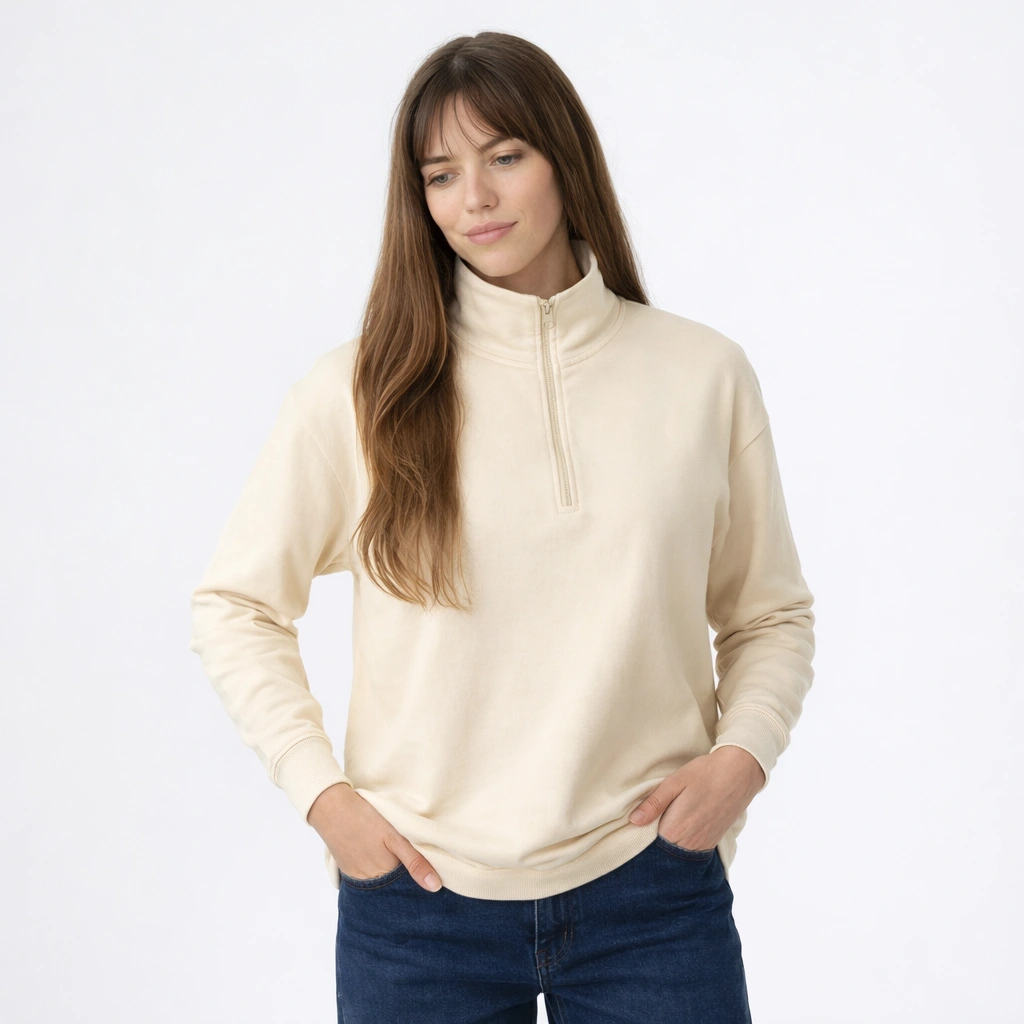 Mulher com blusão de meia cremalheira bege e calças de ganga.