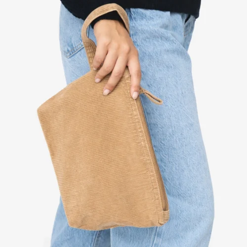 Beige bombazine pouch with a strap and zipper, being held by a hand.