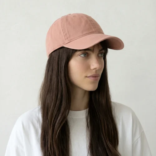 Woman with brown hair and white top, wearing a pink cap.