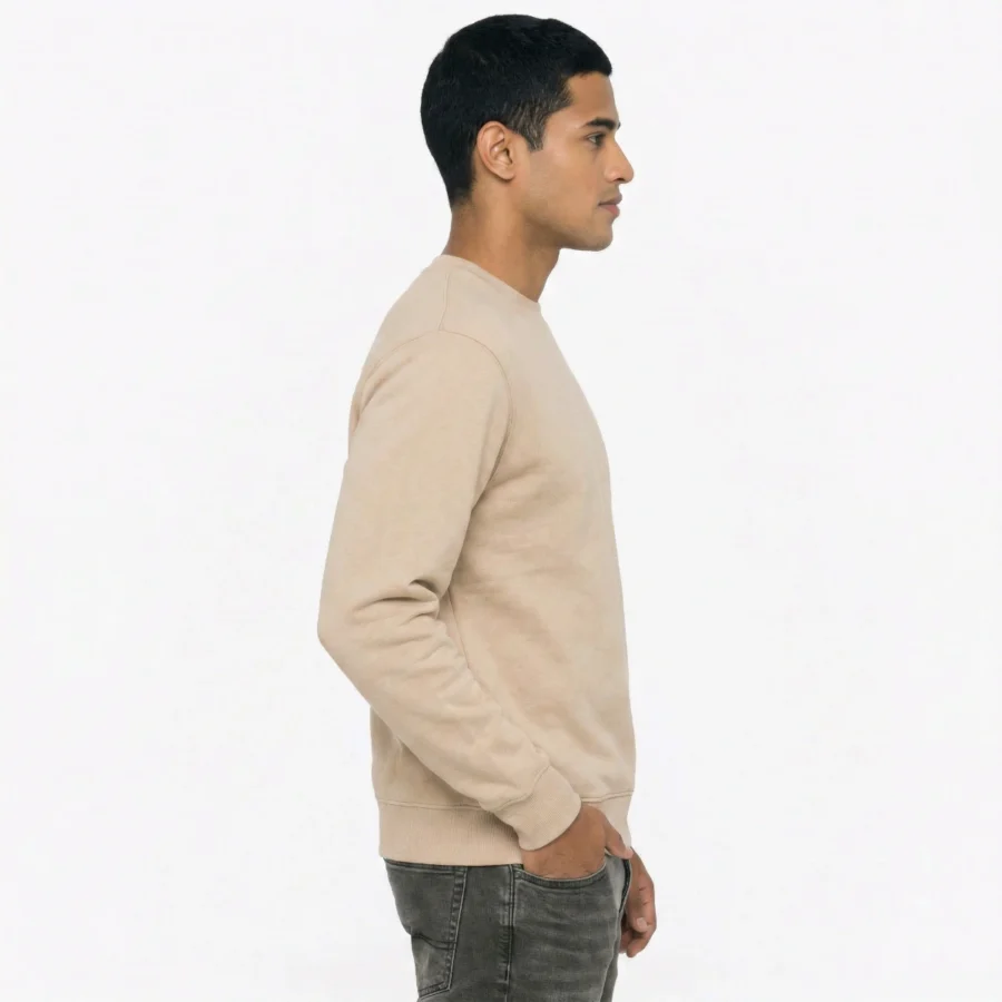 Homem a usar sweatshirt crew neck bege, de lado, contra fundo branco.