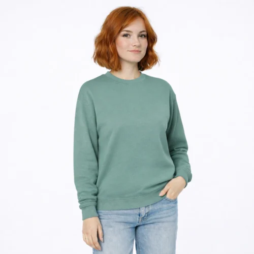 Woman with red hair wearing a green sweatshirt and jeans.