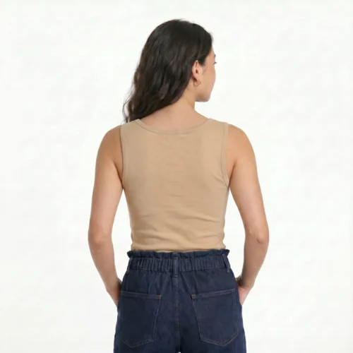 Woman from behind wearing a beige top and dark denim pants.