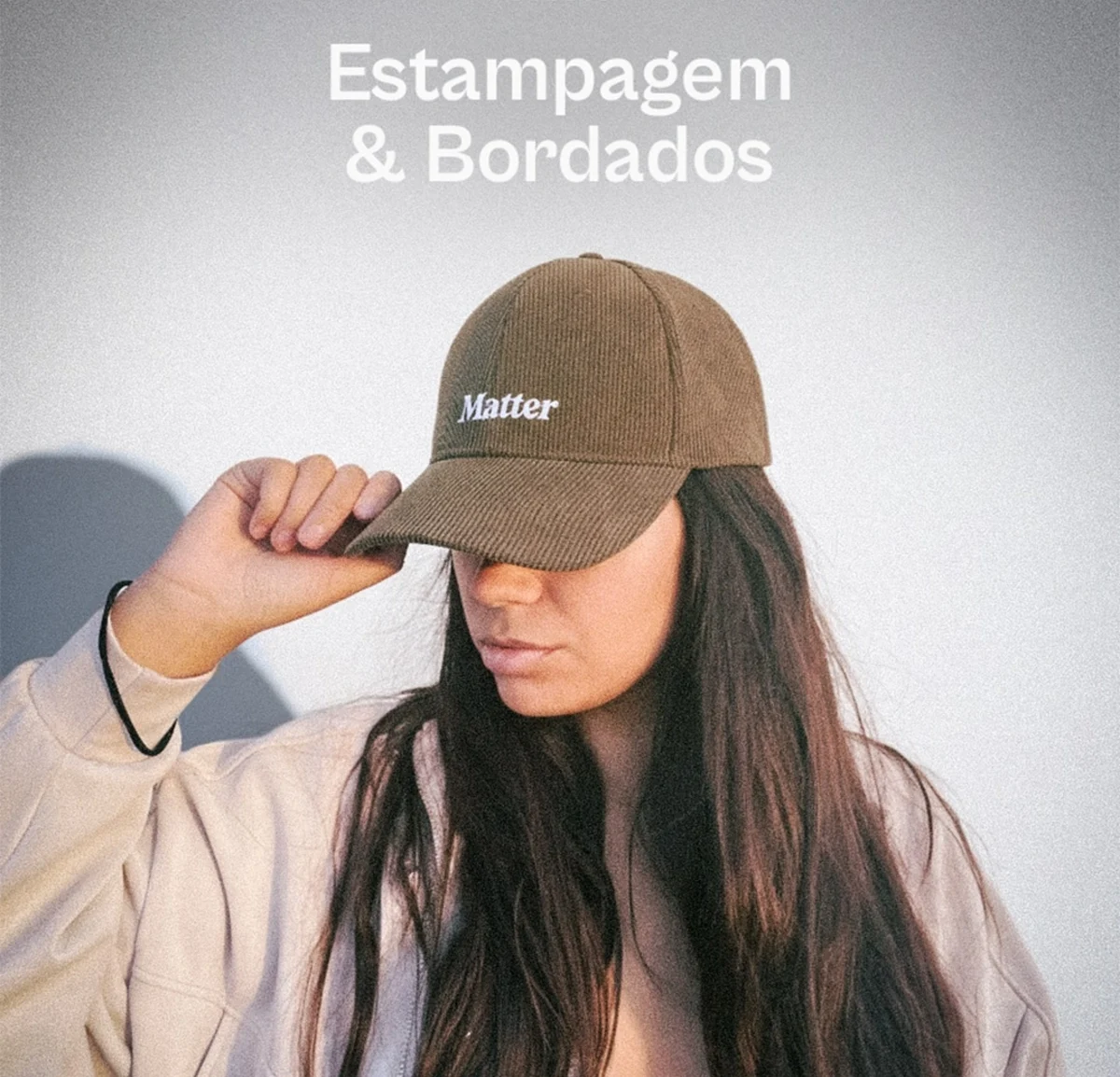 Mulher a ajustar boné castanho Matter, com texto "Estampagem & Bordados" acima.