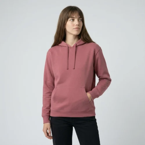 Woman with brown hair wearing a pink unisex hoodie with a waistband and pockets.