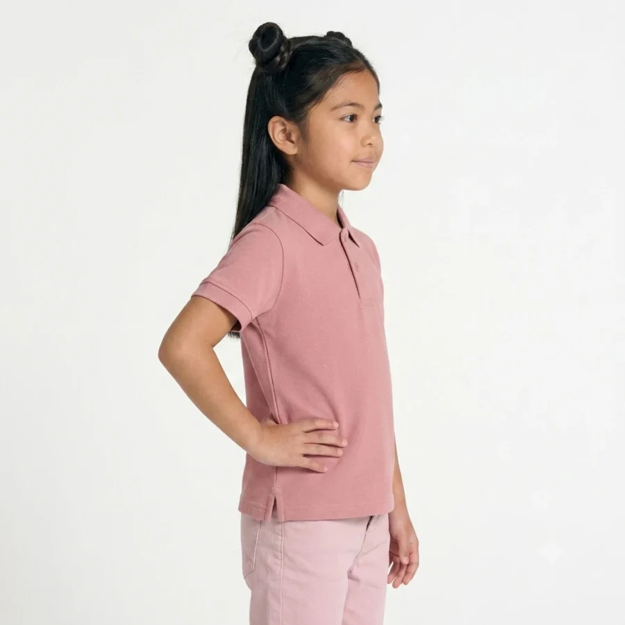 Menina asiática com cabelo preto, vestido com polo e calças cor-de-rosa.