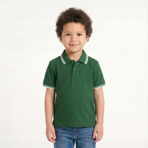 Boy with curly brown hair wearing a green polo with white details and jeans.