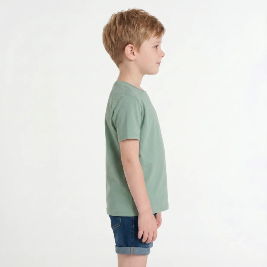 Menino de perfil com t-shirt verde e bermuda azul.