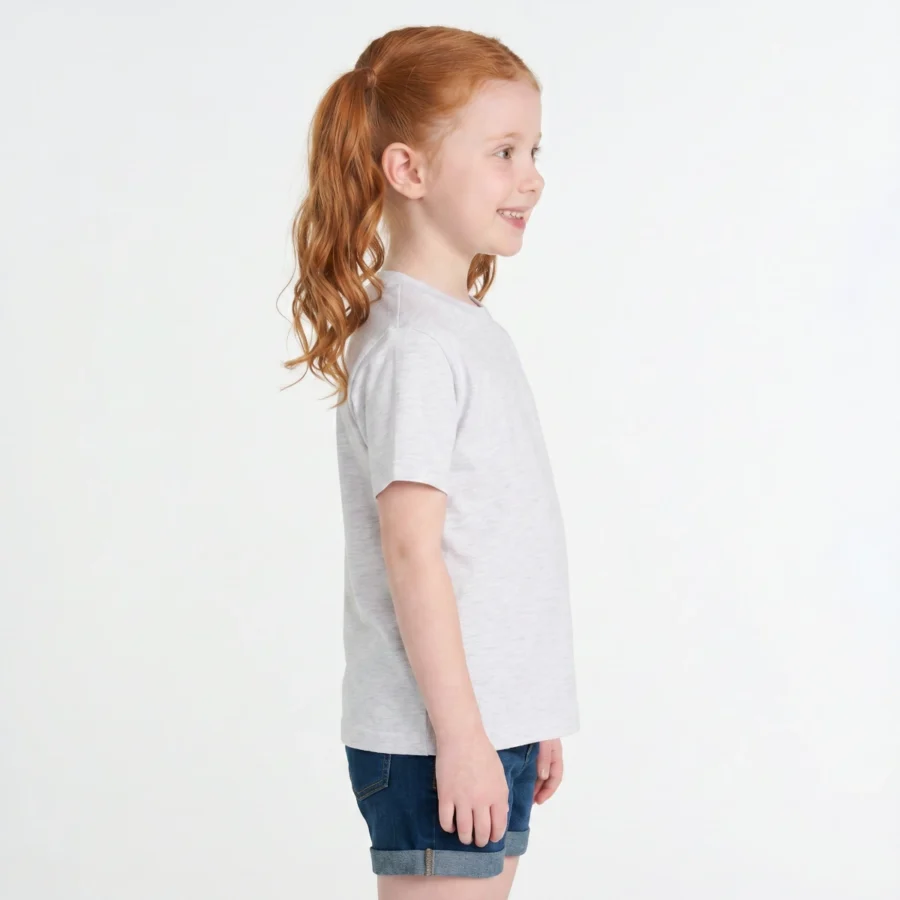 Menina ruiva de perfil com t-shirt cinza claro e shorts jeans.